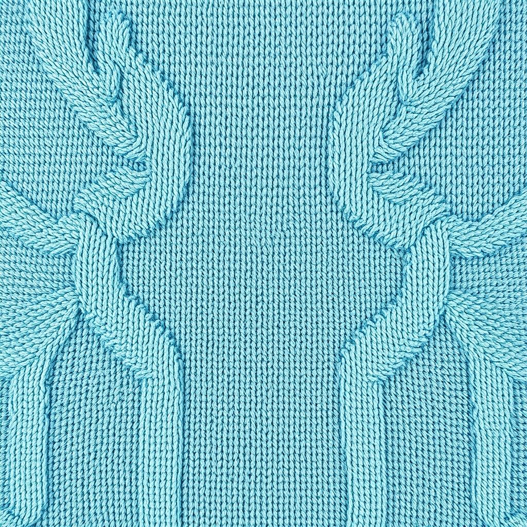 Gros plan sur un tapis turquoise texturé illustrant la qualité et la finesse des fibres naturelles.